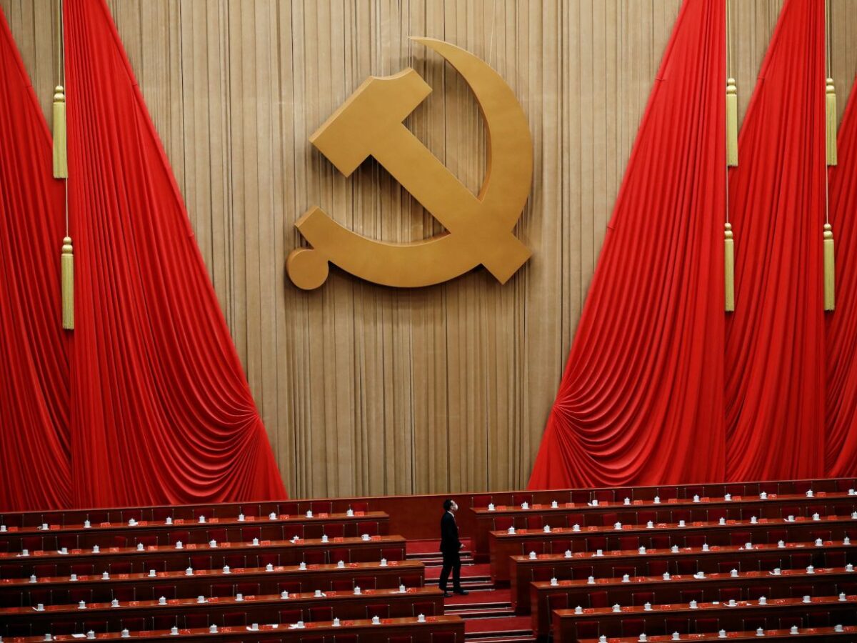 A man stands under the Chinese Communist Party emblem at the end of the closing ceremony. Tingshu Wang Reuters